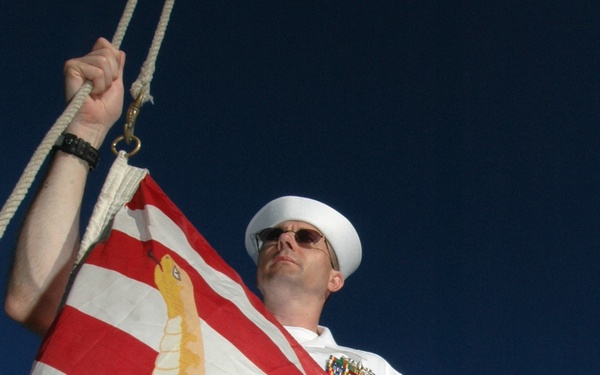 Petty Officer 1st Class Stephen Cornell prepares to raise the Navy Jack.
