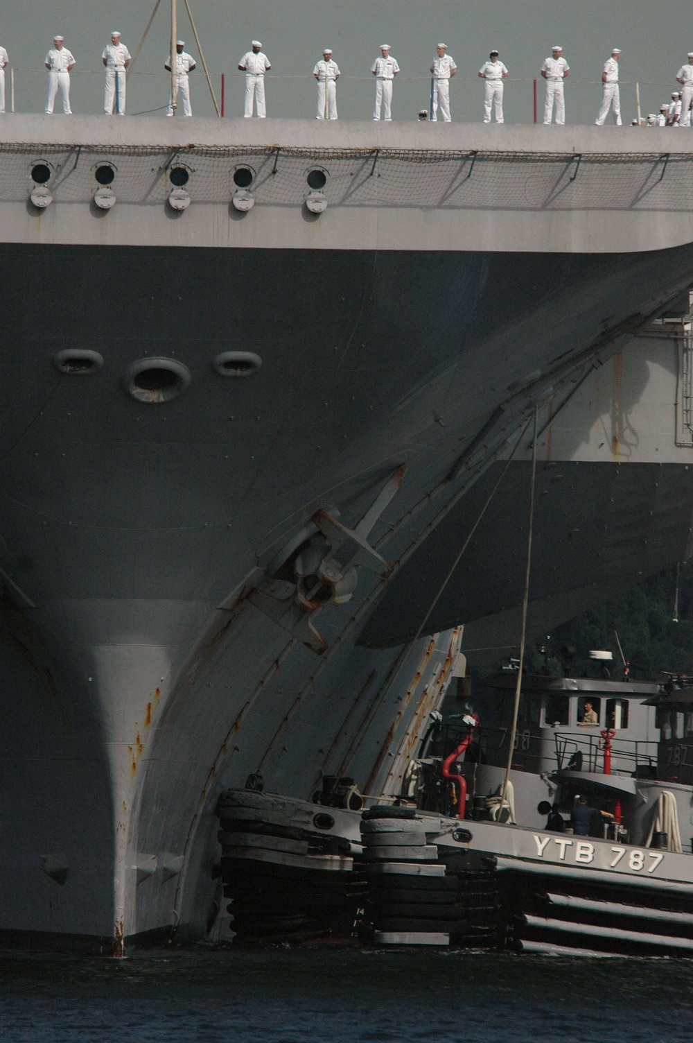 Crewmembers of the aircraft carrier USS Kitty Hawk (CV 63) man the rails.
