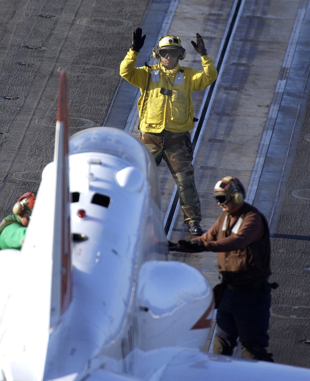 Officer 2nd Class Rodney Martinez guides a T-45 Goshawk into position.