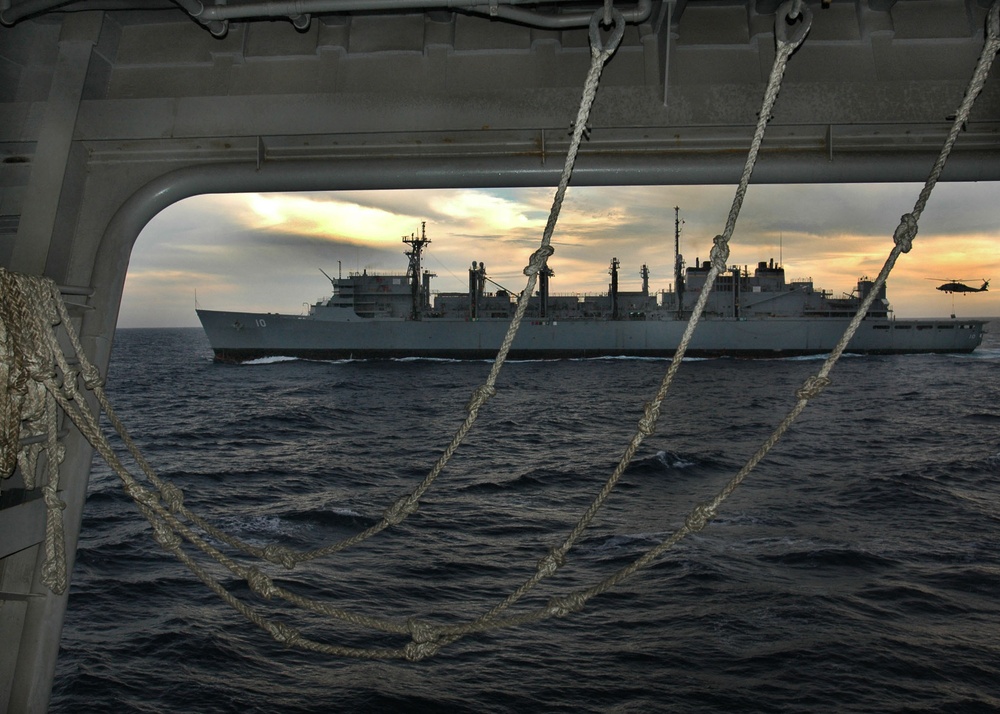 An HH-60H Seahawk helicopter delivers supplies to the USNS Bridge (T-AOE 10).