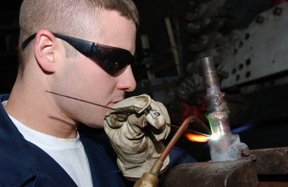 Fireman James Sawyer brazes a pipe.
