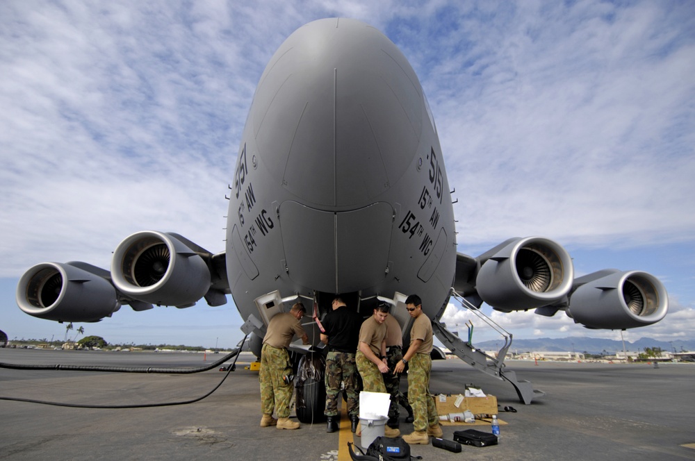 U.S. and Australian Air Force maintenance personnel work on a C-17.
