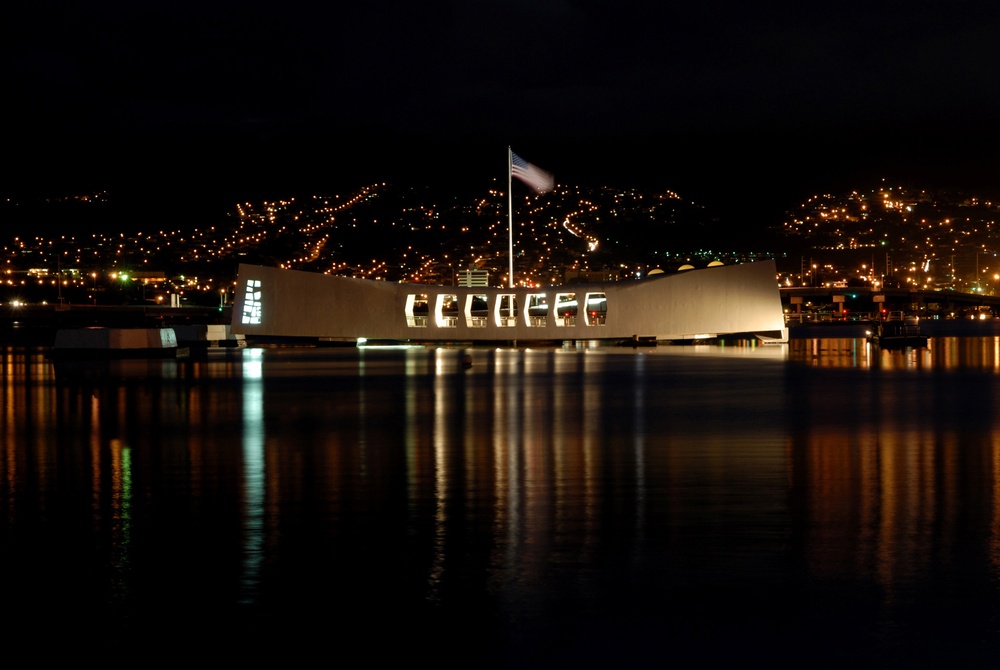 The USS Arizona Memorial glows in the night in Pearl Harbor, Hawaii.