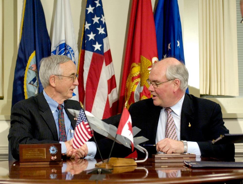 Deputy Secretary England and Canadian Deputy Minister of Defence Ward P. D. Elcock shake hands after signing a memorandum.
