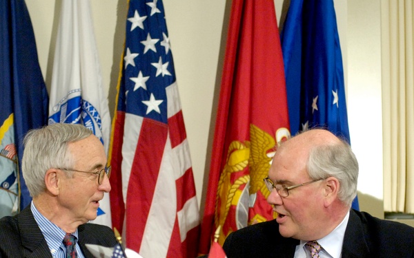 Deputy Secretary England and Canadian Deputy Minister of Defence Ward P. D. Elcock shake hands after signing a memorandum.