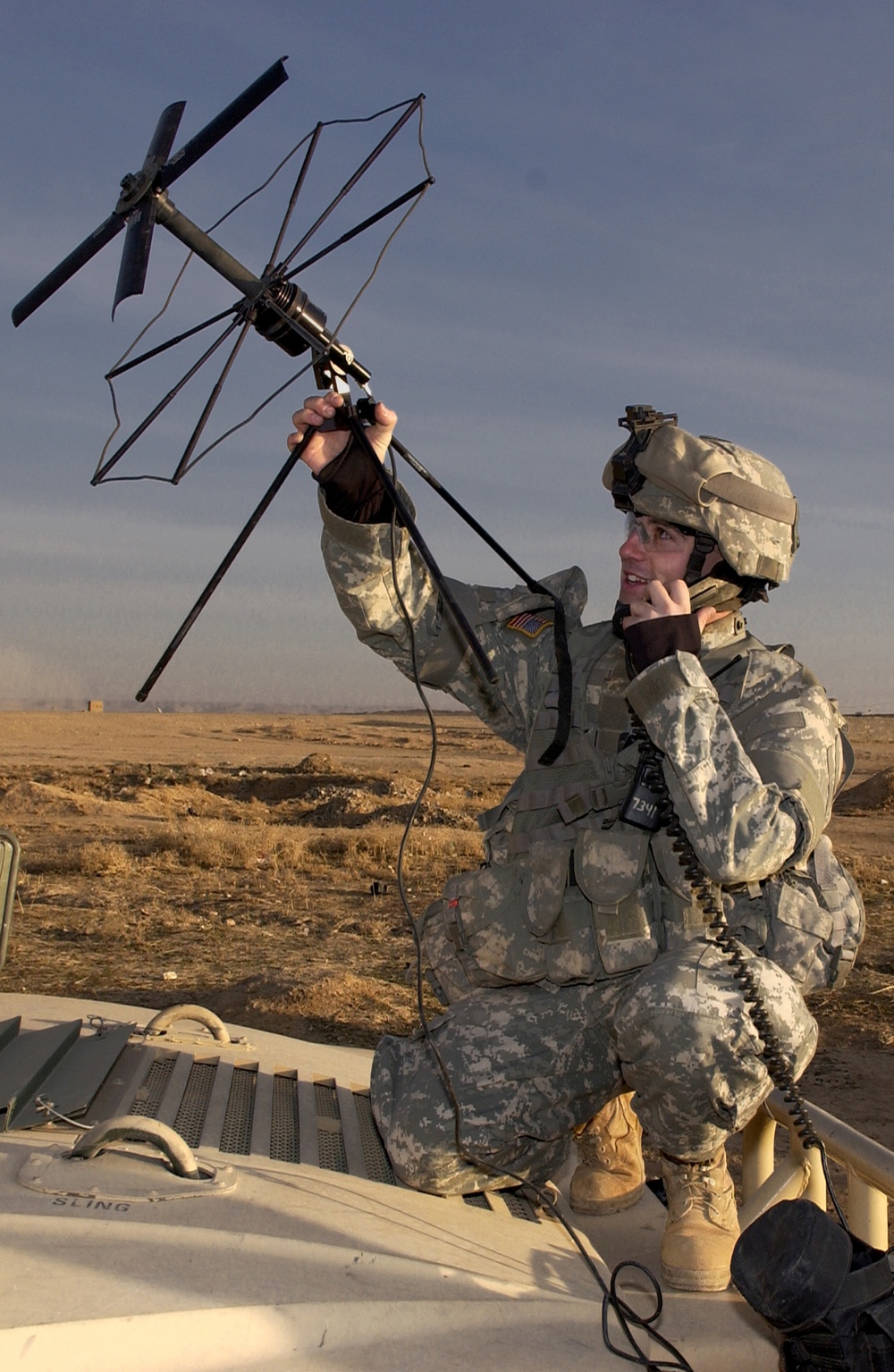 Army Spc. Kerry Lampkin points a satellite communications antenna.