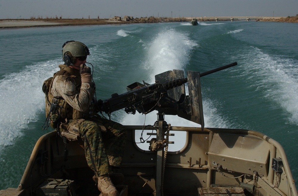 A U.S. Marine mans a weapon aboard a small unit riverine craft.