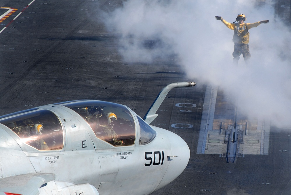 A U.S. Navy flight deck crewman directs an EA-6B Prowler aircraft.