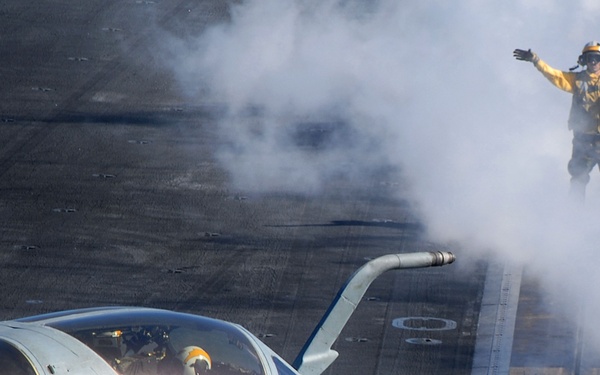 A U.S. Navy flight deck crewman directs an EA-6B Prowler aircraft.
