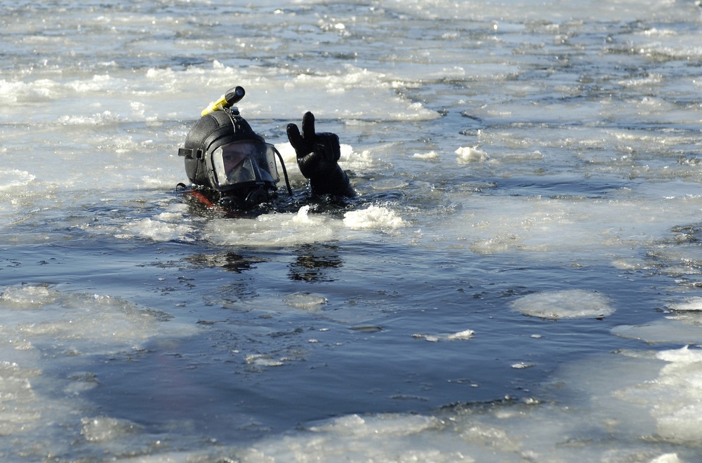 U.S. Navy Diver Petty Officer 3rd Class John Seagraves signals that he is okay.