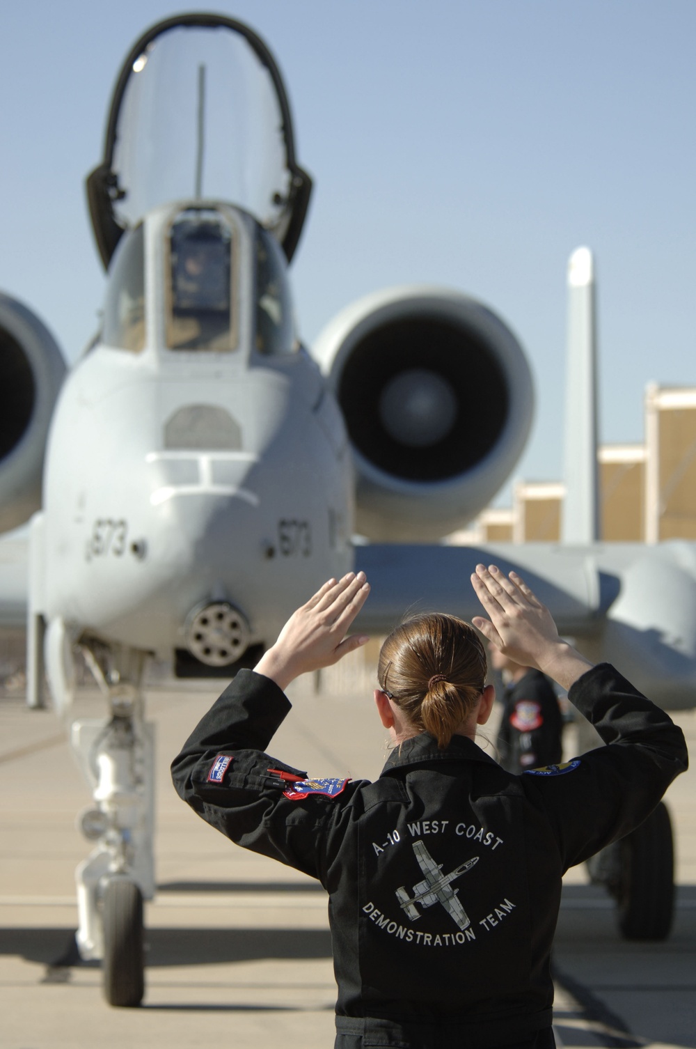 Staff Sgt. Jennifer Eriksen guides an A-10 Thunderbolt II aircraft into position.