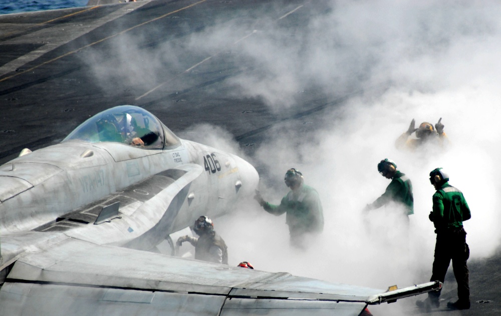 Steam from the steam-powered catapult surrounds flight deck crewman.