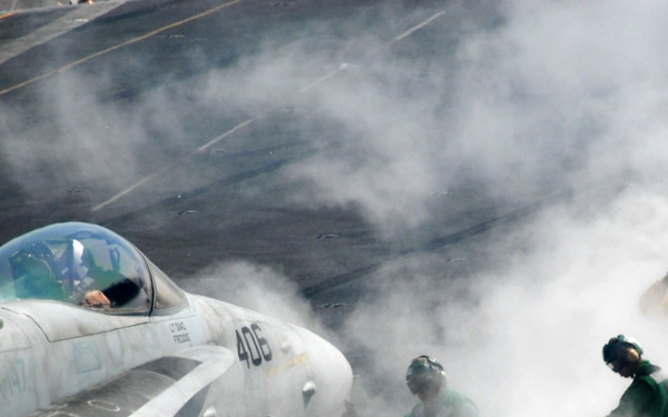 Steam from the steam-powered catapult surrounds flight deck crewman.