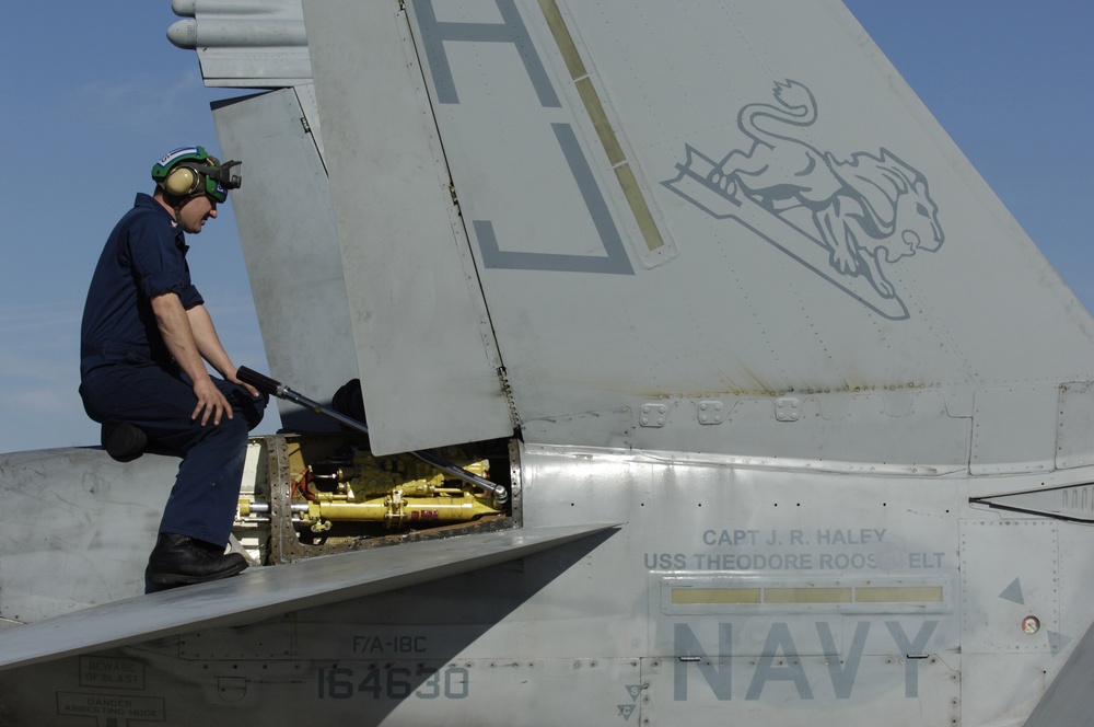 Petty Officer 3rd Class Vincent Kissinger repairs an actuator assembly on an F/A-18 Hornet.