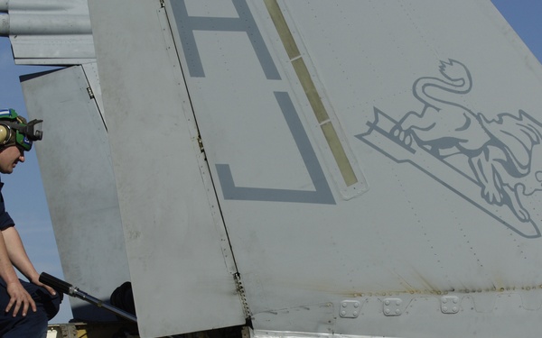 Petty Officer 3rd Class Vincent Kissinger repairs an actuator assembly on an F/A-18 Hornet.