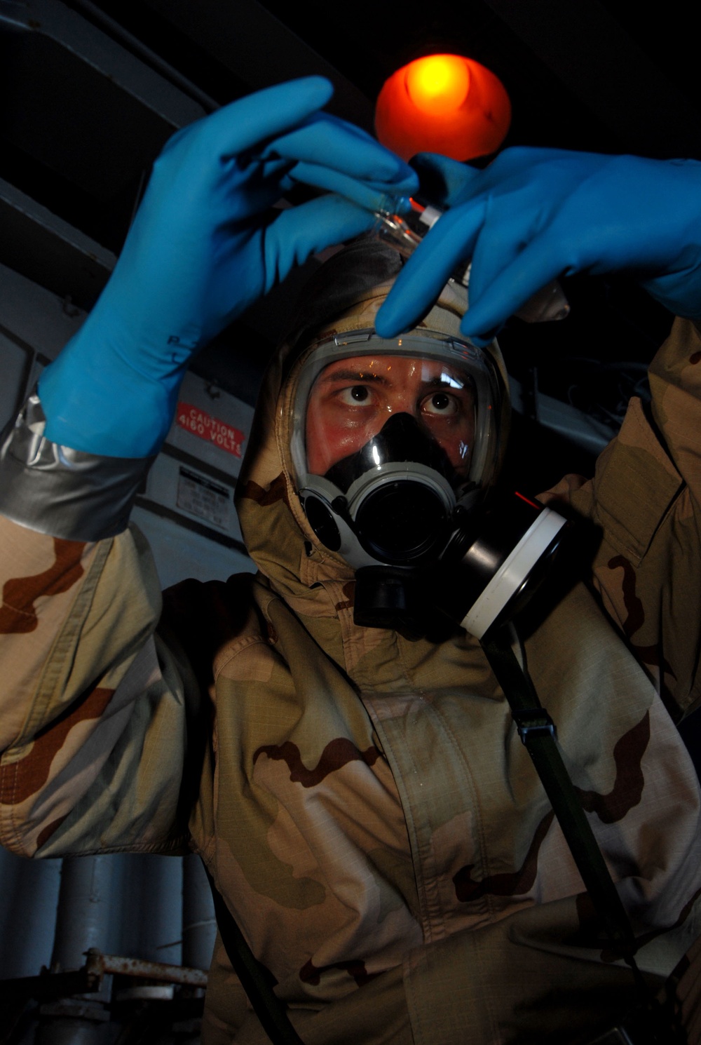 Petty Officer 2nd Class Joshua Frei uses an eye dropper to retrieve mock chemical samples.