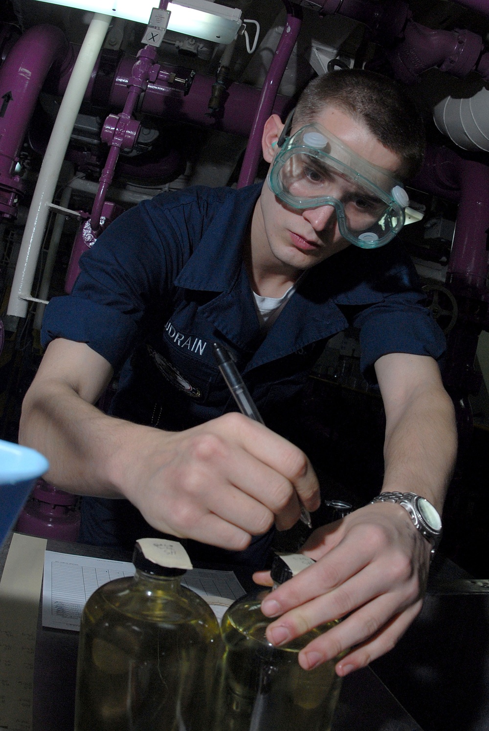 U.S. Navy Airman Nicholas Audrian labels aircraft fuel samples.
