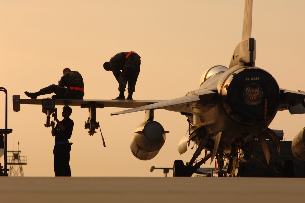 U.S. Air Force crew chiefs prepare an F-16 Fighting Falcon aircraft to be launched.