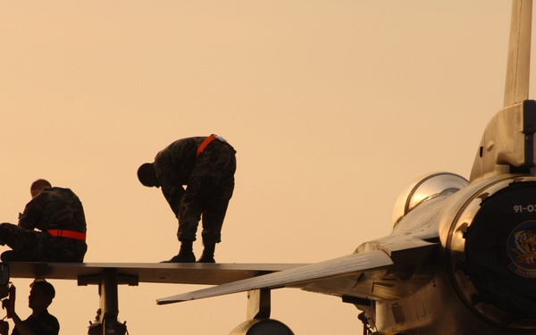 U.S. Air Force crew chiefs prepare an F-16 Fighting Falcon aircraft to be launched.