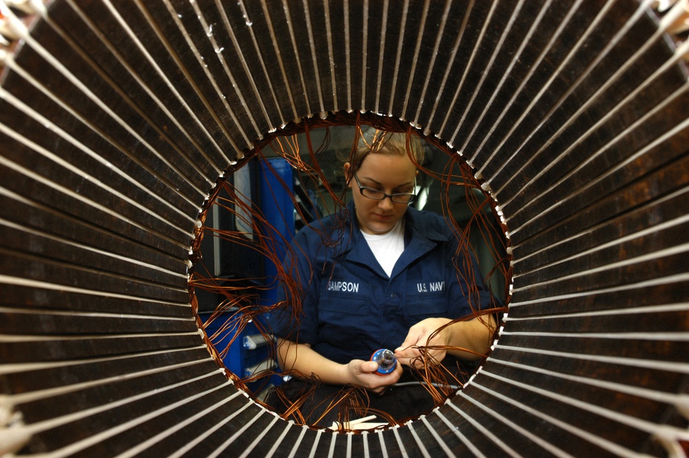 U.S. Navy Electrician's Mate Seaman Angela Sampson strips and spins wire.