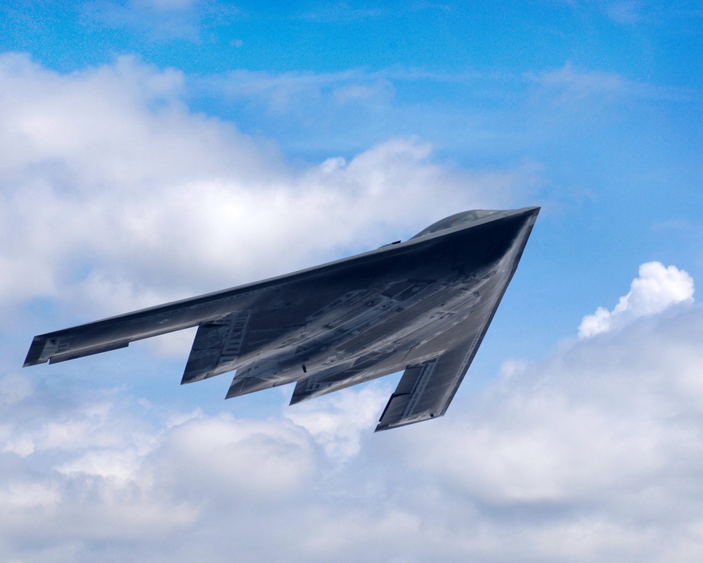 A U.S. Air Force B-2 Spirit aircraft flies during career day.