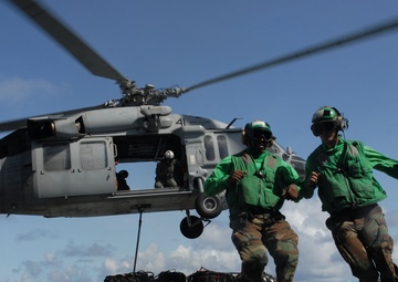 U.S. Navy sailors run clear from the flight deck.