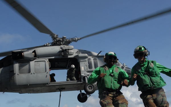 U.S. Navy sailors run clear from the flight deck.