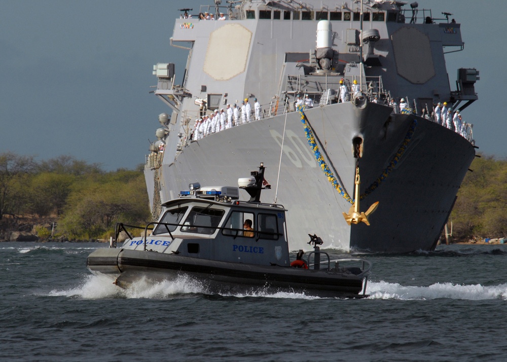 A harbor patrol boat leads the way for the USS Paul Hamilton (DDG 60).
