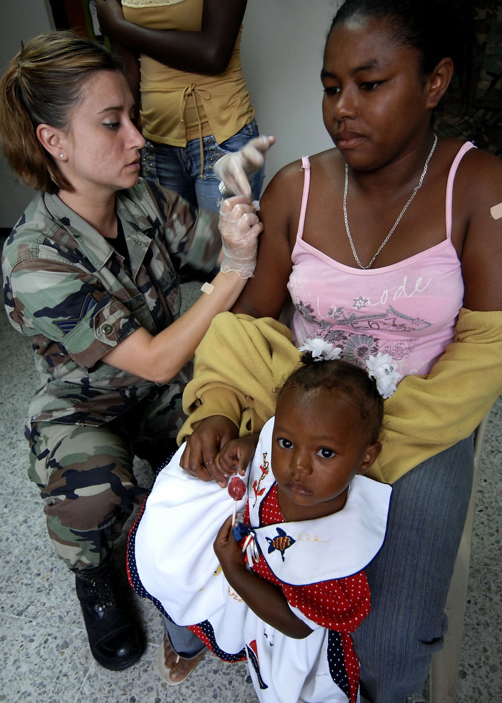 Senior Airman Audrey Lutz gives an immunization shot to a patient.