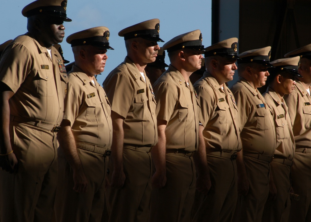 U.S. Navy chief petty officers stand at attention.