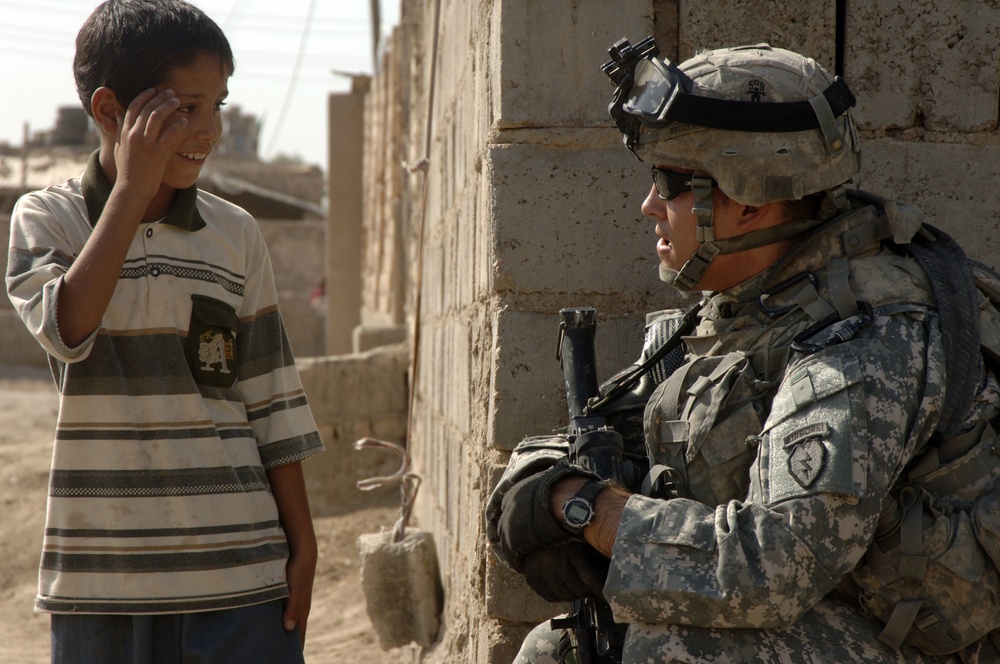 A U.S. Army soldier talks to an Iraqi child.