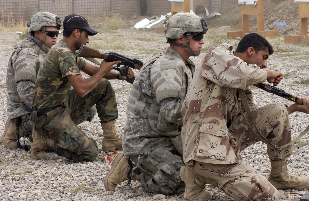 U.S. Army soldiers check to see if Iraqi police officers weapons' are clear.