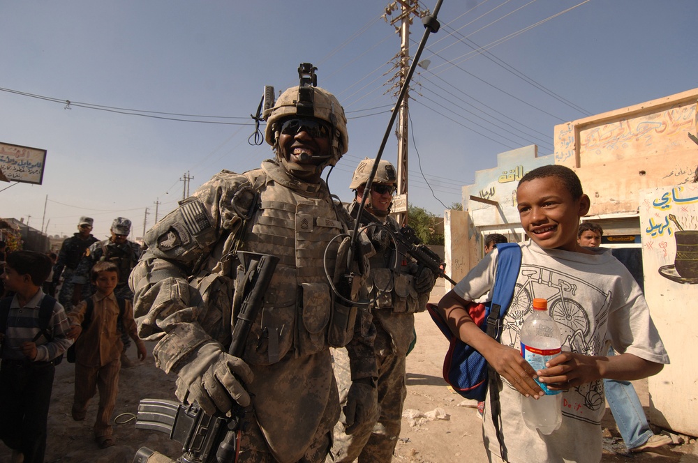Sgt. 1st Class David Bess tells jokes with an Iraqi child.
