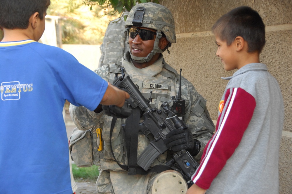 Staff Sgt. Christopher Currie talks with two Iraqi boys.
