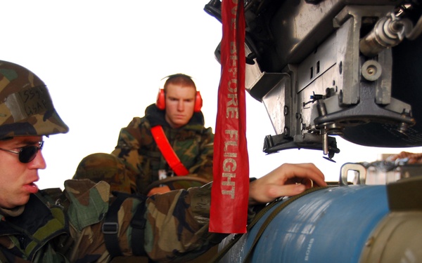 Staff Sgt. Mikel Parrish (left) and Airman 1st Class Patrick Ward load a BDU-50 practice bomb.