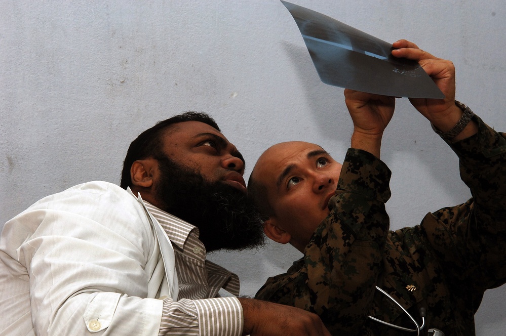 Lt. Cmdr. Lu Le looks over a patient's x-ray. Lt. Cmdr. Lu Le looks over a patient's x-ray.