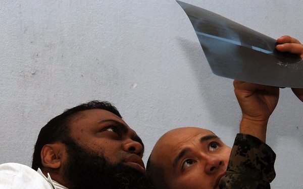 Lt. Cmdr. Lu Le looks over a patient's x-ray.
