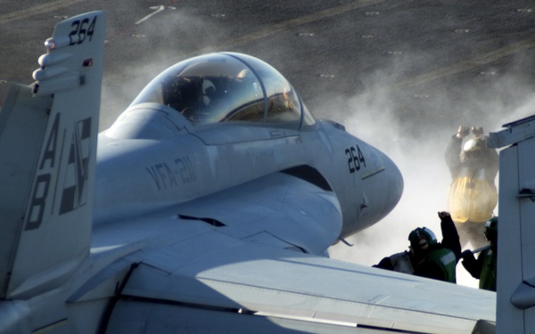 A U.S. Navy F/A-18 Super Hornet aircraft is prepared for a catapult launch.