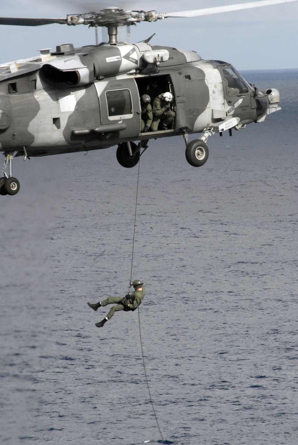 A U.S. Navy explosive ordnance disposal technician repels from an HH-60H Sea Hawk helicopter.