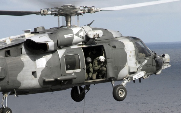 A U.S. Navy explosive ordnance disposal technician repels from an HH-60H Sea Hawk helicopter.