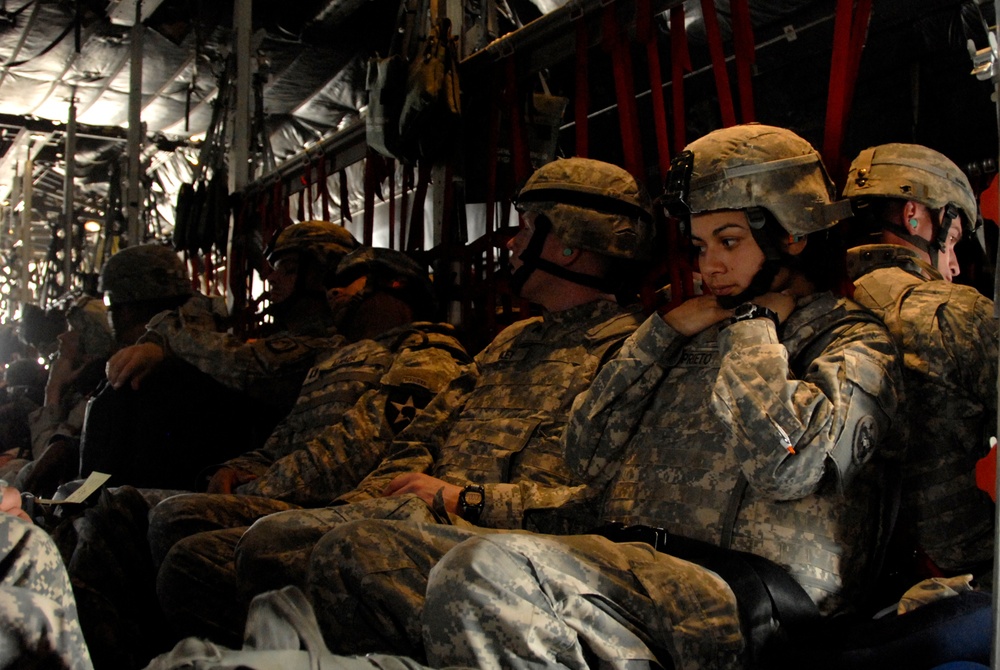 U.S. Army soldiers patiently wait in the seats of a U.S. Air Force C-130 Hercules aircraft.