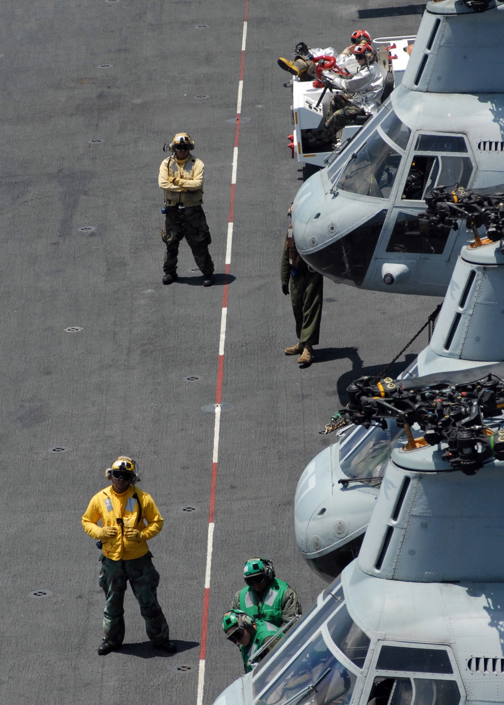U.S. Navy flight deck crew members monitor the safety line.