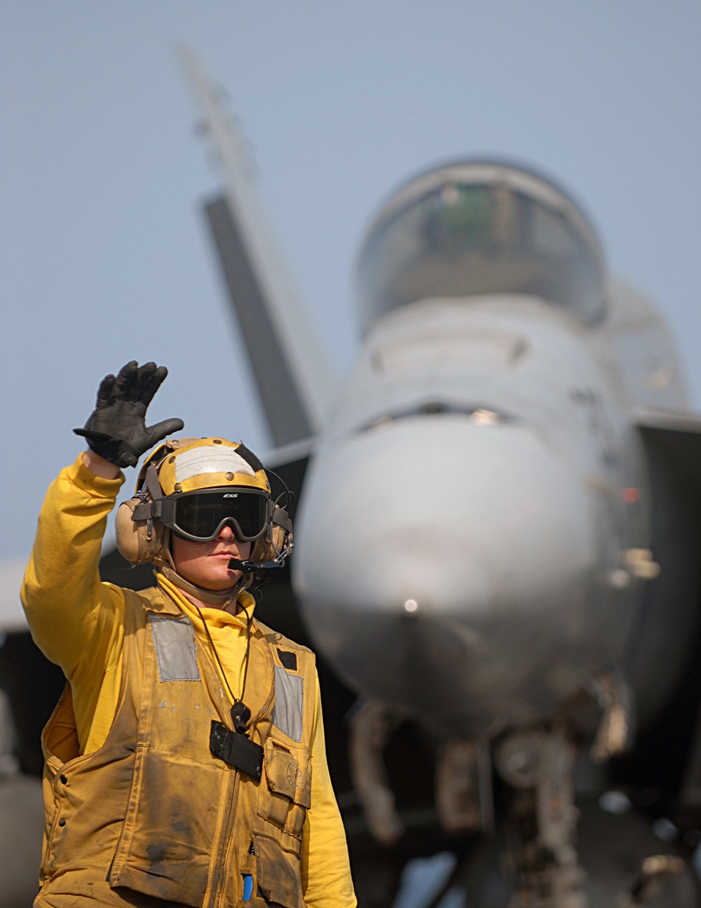 DVIDS - Images - A U.S. Navy aircraft director signals to a tractor driver.