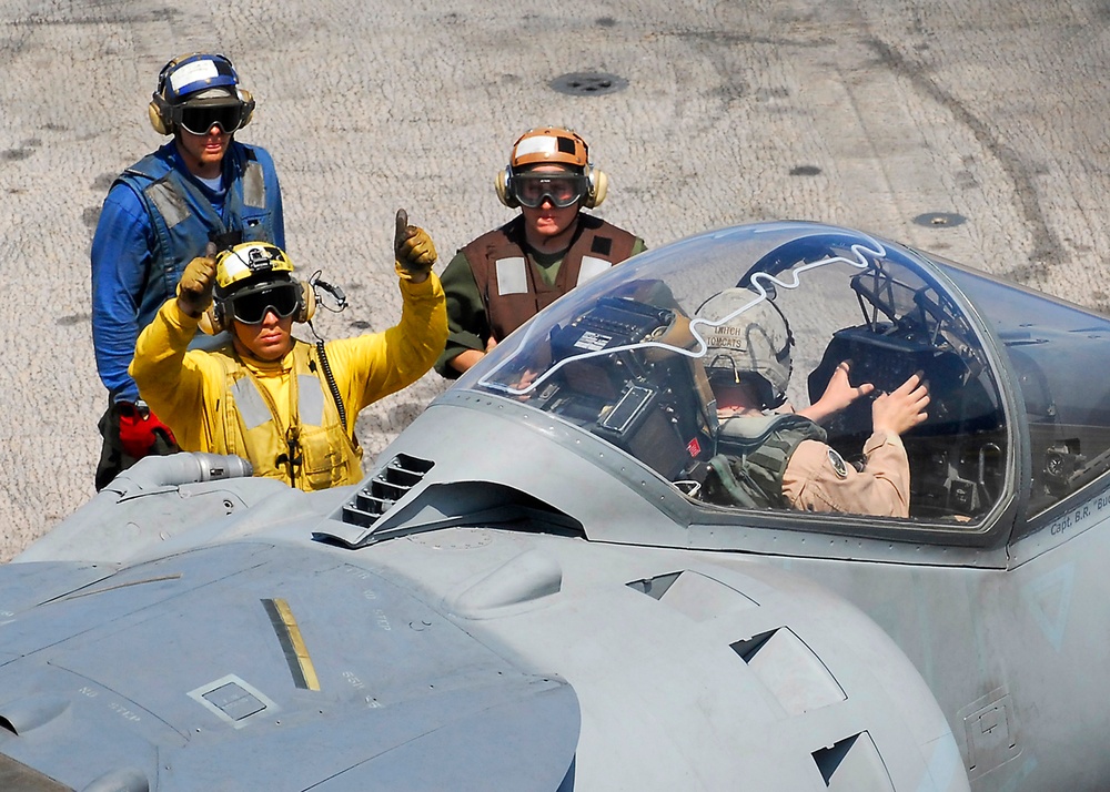 U.S. Navy flight deck crewmen use hand signals.