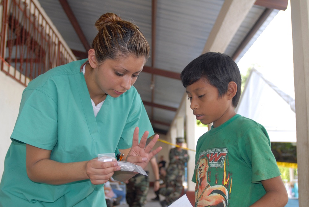 Aviation Boatswain's Mate Airman Amy Saavedra explains medicine dosage instructions.