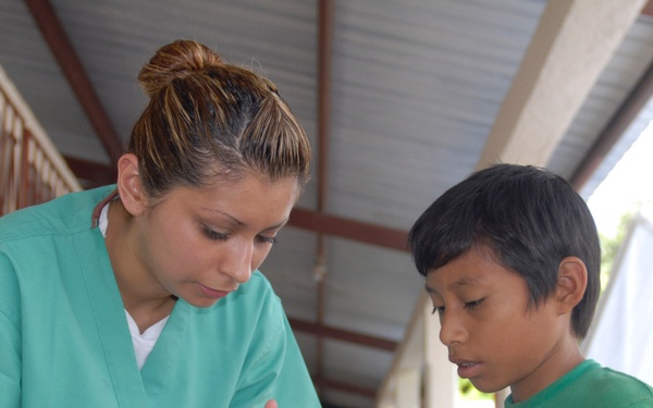 Aviation Boatswain's Mate Airman Amy Saavedra explains medicine dosage instructions.