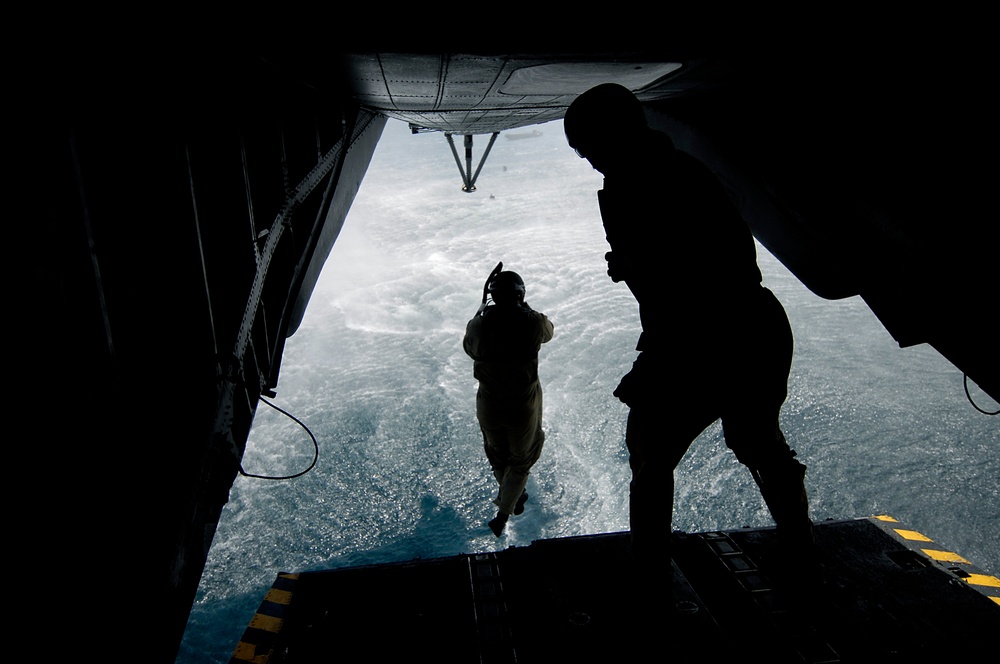 U.S. Navy Diver 1st Class Adam Eddingfield jumps off the back ramp of an MH-53 Pave Low helicopter.