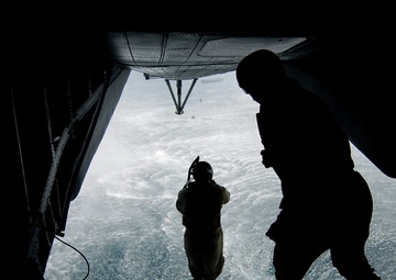 U.S. Navy Diver 1st Class Adam Eddingfield jumps off the back ramp of an MH-53 Pave Low helicopter.