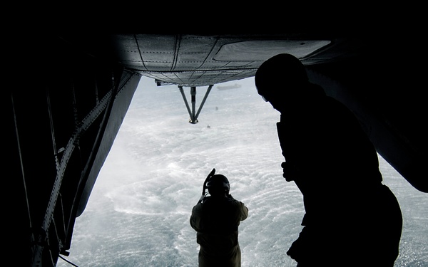 U.S. Navy Diver 1st Class Adam Eddingfield jumps off the back ramp of an MH-53 Pave Low helicopter.