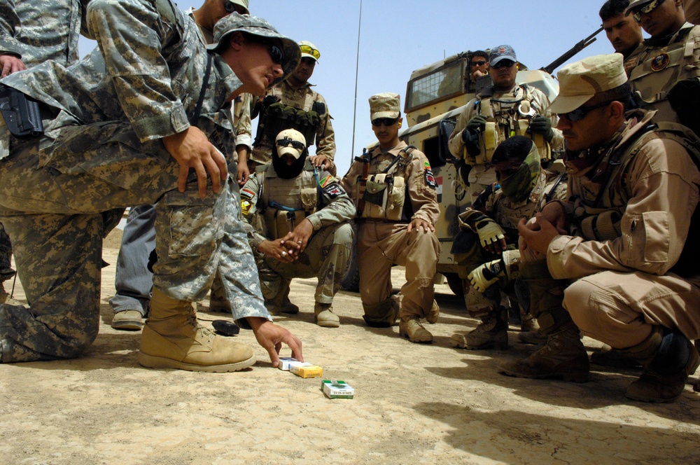 U.S. and Iraqi soldiers gather around for an after-action review.